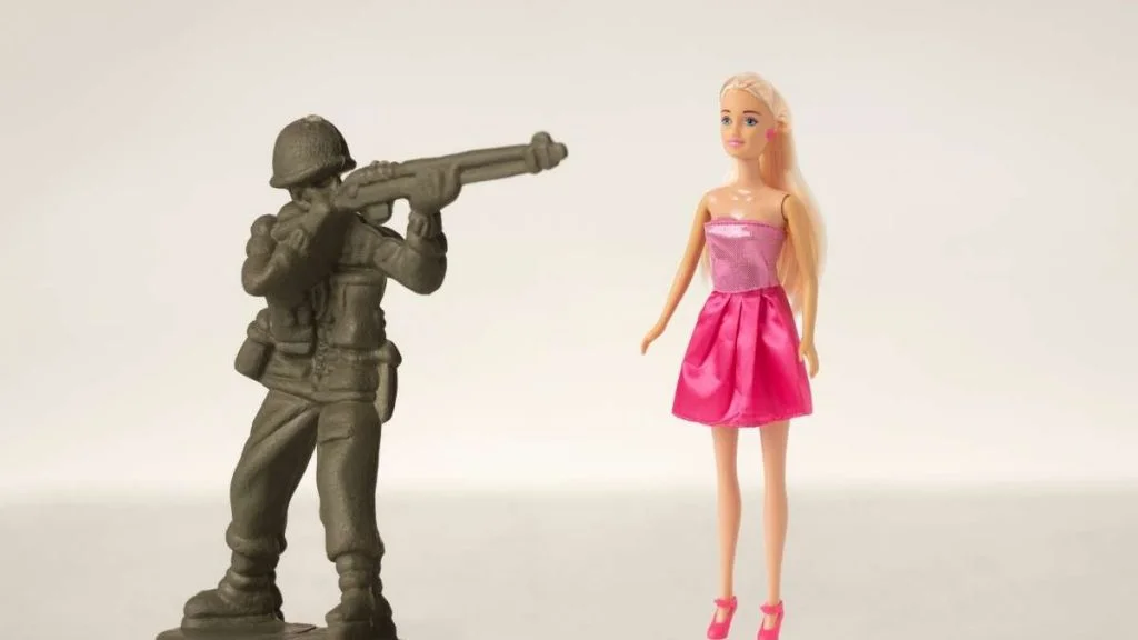 Imagem atual: soldado de brinquedo apontando para barbie