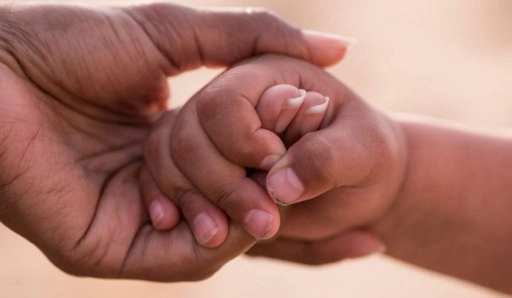 Imagem atual: mãe segurando mão do filho